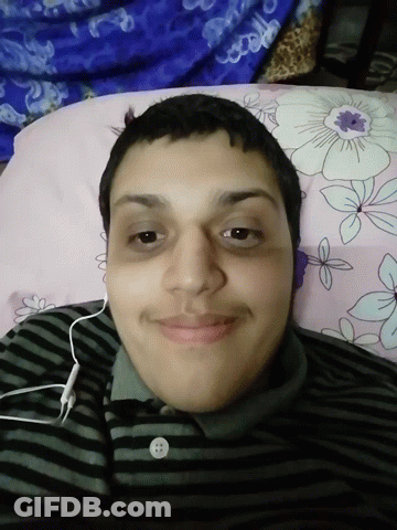 A Man Wearing Headphones Is Laying On A Bed GIF
