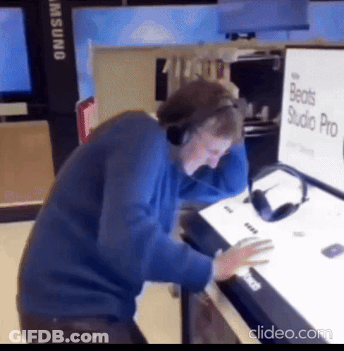 A Man Wearing Headphones Is Looking At A Beats Studio Pro Sign GIF