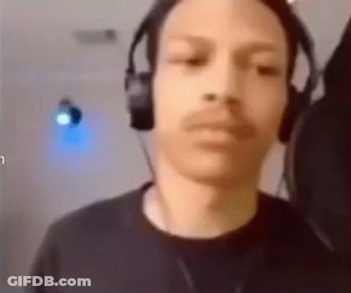 A Man Wearing Headphones Is Looking At The Camera And Making A Funny Face . GIF