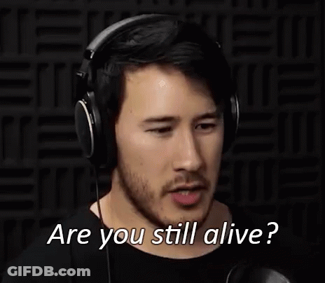 A Man Wearing Headphones Is Making A Funny Face And Asking Are You Still Alive . GIF