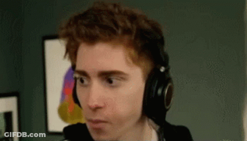 A Man Wearing Headphones Is Making A Funny Face And Looking At The Camera . GIF