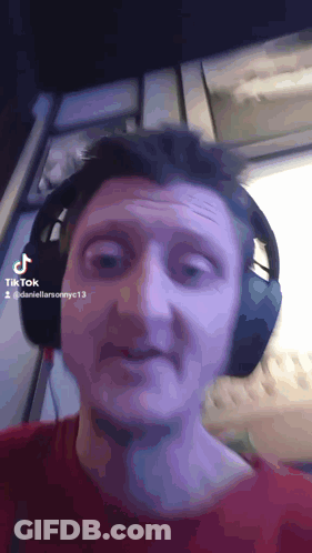 A Man Wearing Headphones Is Making A Funny Face In A Tik Tok Video GIF