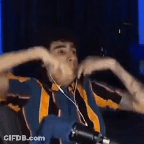 A Man Wearing Headphones Is Making A Funny Face In Front Of A Microphone . GIF