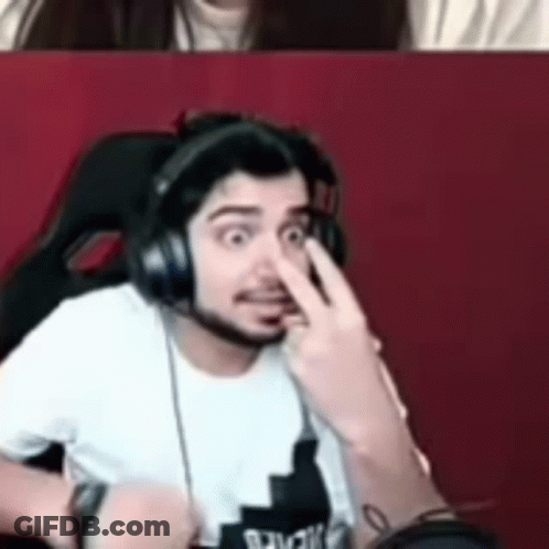 A Man Wearing Headphones Is Making A Funny Face While A Woman Looks On . GIF