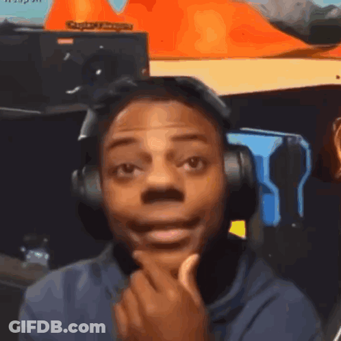 A Man Wearing Headphones Is Making A Funny Face While Looking At The Camera . GIF