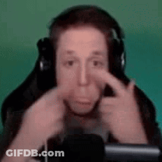 A Man Wearing Headphones Is Making A Funny Face While Sitting In Front Of A Microphone . GIF