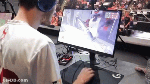 A Man Wearing Headphones Is Playing A Video Game On A Dell Computer GIF