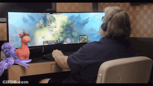 A Man Wearing Headphones Is Playing A Video Game On His Computer GIF