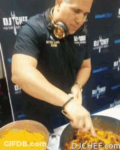 A Man Wearing Headphones Is Preparing Food In Front Of A Wall That Says Dj Chef GIF