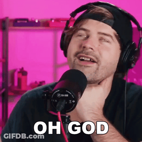 A Man Wearing Headphones Is Singing Into A Microphone And Says Oh God . GIF