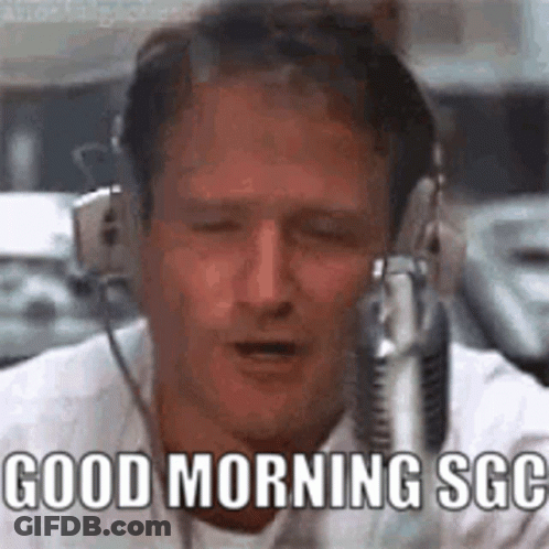A Man Wearing Headphones Is Singing Into A Microphone . GIF