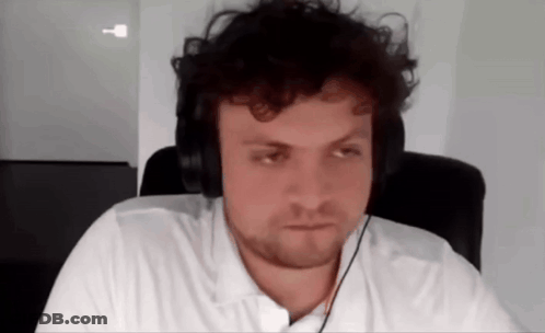 A Man Wearing Headphones Is Sitting In A Chair . GIF
