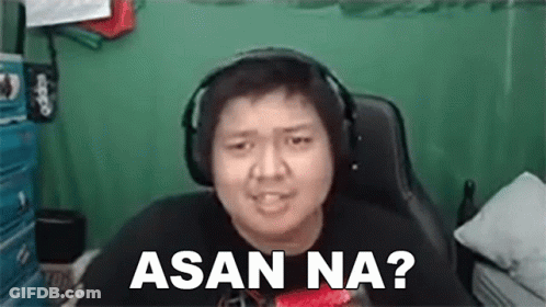 A Man Wearing Headphones Is Sitting In A Chair And Making A Face . GIF