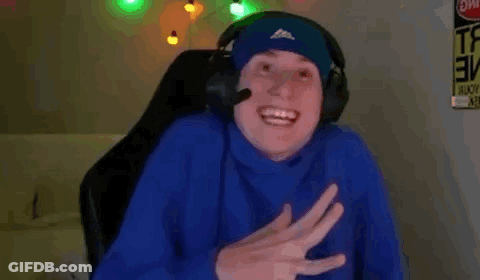 A Man Wearing Headphones Is Sitting In A Chair And Smiling . GIF