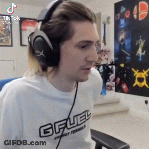 A Man Wearing Headphones Is Sitting In A Chair In A Living Room . GIF