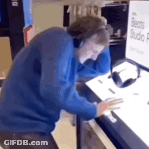 A Man Wearing Headphones Is Sitting In Front Of A Computer . GIF
