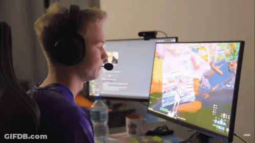 A Man Wearing Headphones Is Sitting In Front Of A Computer Monitor GIF