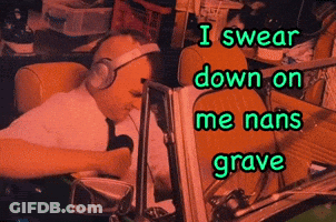 A Man Wearing Headphones Is Sitting In Front Of A Computer With The Words I Swear Down On Me Nans Grave Below Him GIF