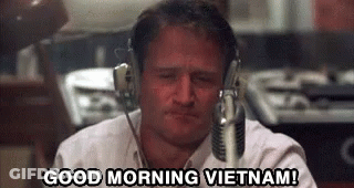 A Man Wearing Headphones Is Sitting In Front Of A Microphone . GIF