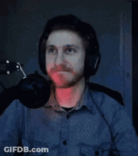 A Man Wearing Headphones Is Sitting In Front Of A Microphone And Looking Up . GIF