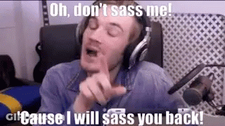 A Man Wearing Headphones Is Sitting In Front Of A Microphone And Making A Face . GIF