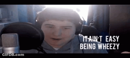 A Man Wearing Headphones Is Sitting In Front Of A Microphone And Making A Funny Face . GIF