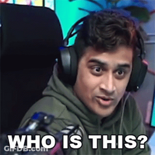 A Man Wearing Headphones Is Sitting In Front Of A Microphone And Making A Funny Face . GIF