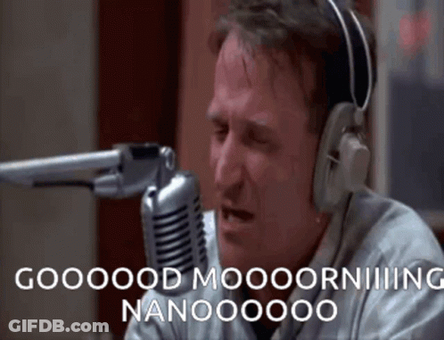 A Man Wearing Headphones Is Sitting In Front Of A Microphone And Saying Good Morning Nanooooo GIF