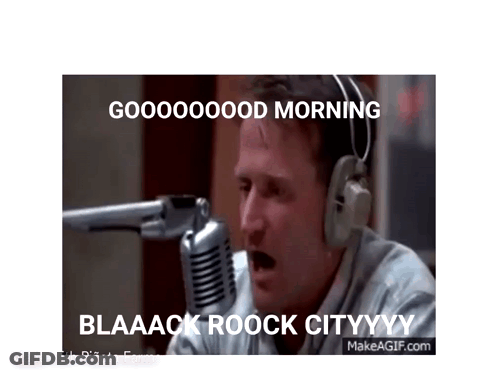 A Man Wearing Headphones Is Sitting In Front Of A Microphone And Saying Good Morning . GIF