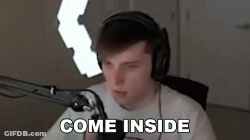 A Man Wearing Headphones Is Sitting In Front Of A Microphone And Says `` Come Inside '' . GIF