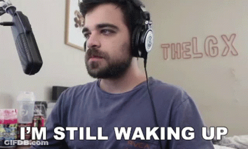 A Man Wearing Headphones Is Sitting In Front Of A Microphone And Says I 'M Still Waking Up GIF