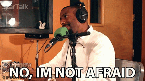 A Man Wearing Headphones Is Sitting In Front Of A Microphone And Says No Im Not Afraid GIF