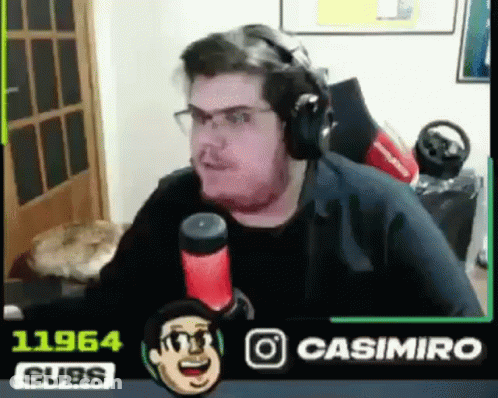 A Man Wearing Headphones Is Sitting In Front Of A Microphone In A Room . GIF