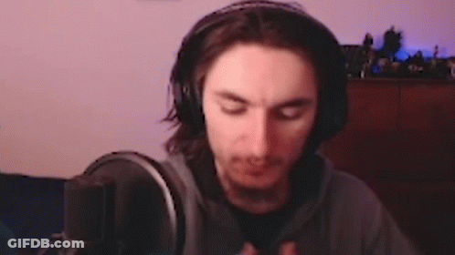 A Man Wearing Headphones Is Sitting In Front Of A Microphone In A Room . GIF