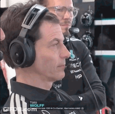A Man Wearing Headphones Is Sitting In Front Of A Microphone While Another Man Looks On . GIF