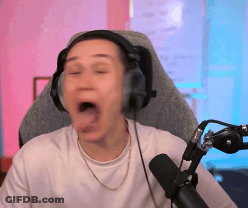 A Man Wearing Headphones Is Sitting In Front Of A Microphone With His Mouth Open GIF