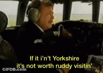 A Man Wearing Headphones Is Sitting In The Cockpit Of A Plane And Talking . GIF