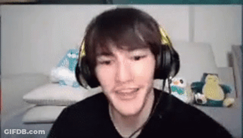 A Man Wearing Headphones Is Sitting On A Couch . GIF
