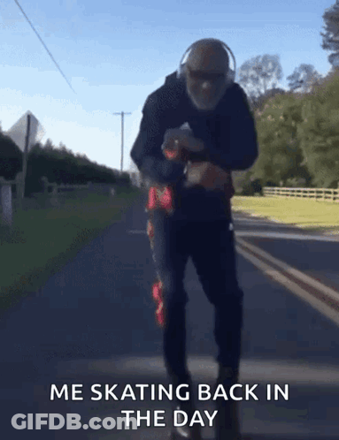 A Man Wearing Headphones Is Skating Down A Road With The Words Me Skating Back In The Day Below Him GIF