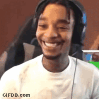 A Man Wearing Headphones Is Smiling And Looking At The Camera . GIF