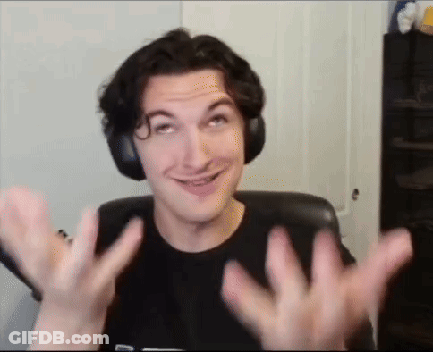 A Man Wearing Headphones Is Smiling And Making A Funny Face While Sitting In A Chair . GIF