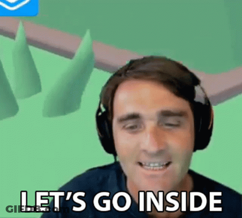 A Man Wearing Headphones Is Smiling And Saying Let 'S Go Inside . GIF