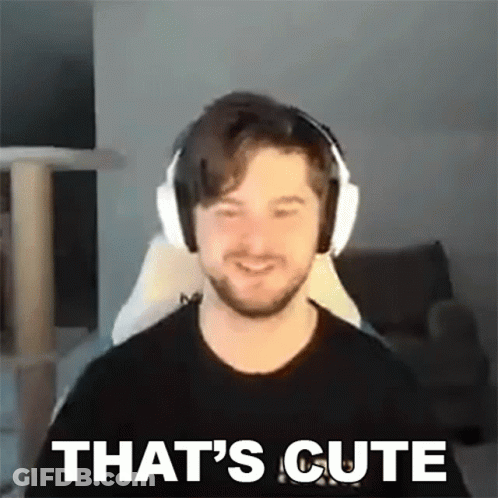A Man Wearing Headphones Is Smiling And Saying `` That 'S Cute '' While Sitting In A Chair . GIF