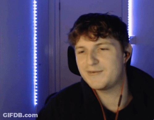 A Man Wearing Headphones Is Smiling In Front Of A Blue Wall GIF