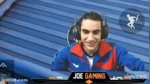 A Man Wearing Headphones Is Smiling In Front Of A Screen That Says Joe Gaming On It GIF
