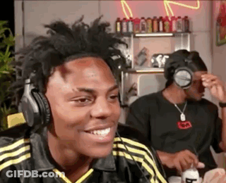 A Man Wearing Headphones Is Smiling While Sitting In A Room . GIF
