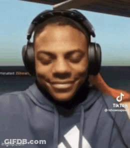 A Man Wearing Headphones Is Smiling With His Eyes Closed GIF