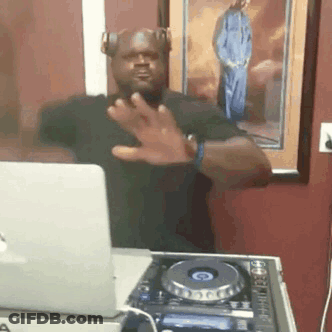 A Man Wearing Headphones Is Standing In Front Of A Laptop And A Dj Controller . GIF