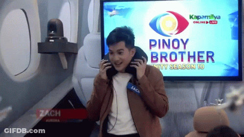 A Man Wearing Headphones Is Standing In Front Of A Screen That Says Pinoy Brother GIF