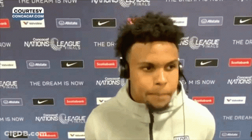 A Man Wearing Headphones Is Standing In Front Of A Wall That Says League Finals GIF